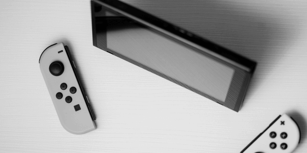 Nintendo Switch console with detached white Joy-Cons placed on a white surface – representing Joy-Con repair and diagnostics.